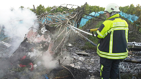 Feuerwehr löscht ausgebranntes Flugzeugwrack