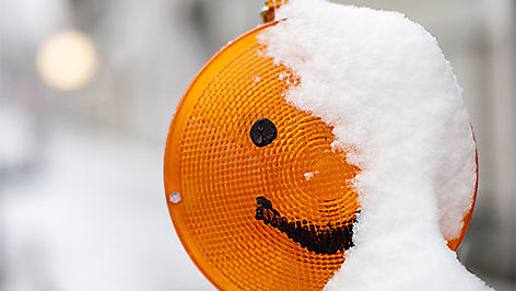 Schneebedeckte Baustellenlampe als Smiley