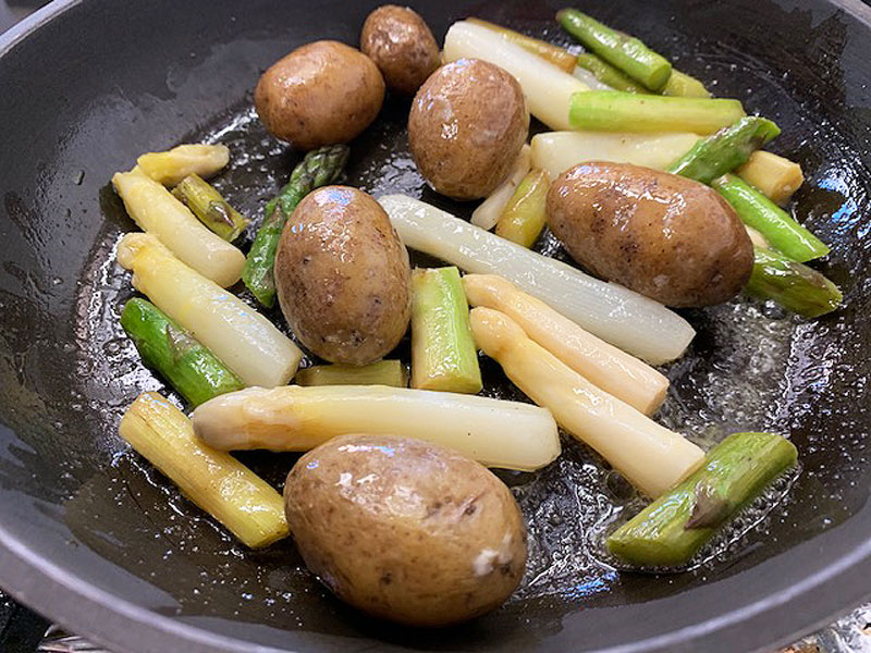 Pannacotta, Köchin pflückt Kräuter im Garten, Spargel und Kartoffeln in der Pfanne,